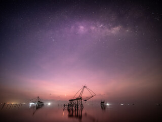 Milky Way with fishing trap net in sea, Nature landscape fisheries and fishing tools lifestyle at Pak Pha, Phatthalung, Thailand.