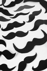 Fake paper mustaches on white background, flat lay