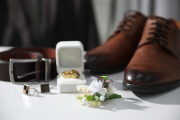 Wedding stuff. Composition with stylish boutonniere on white surface, closeup - obrazy, fototapety, plakaty