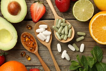 Fototapeta na wymiar Different vitamin pills and fresh fruits on old wooden table, flat lay