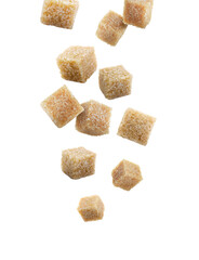 Brown cane sugar cubes falling on white background