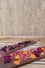 different kinds of chocolate with dried fruits on a wooden board