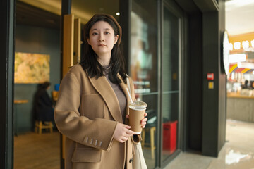 Stylish Young Woman Enjoying Coffee in the City