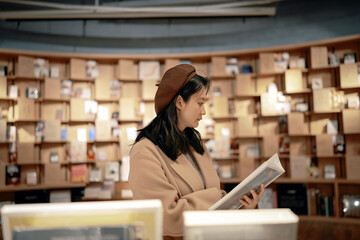 Young Woman Engrossed in Reading at a Cozy Library