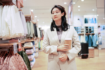 Confident Young Woman Browsing in Fashion Retail Shop
