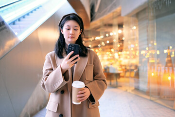 Young Woman Checking Phone in Urban Evening Setting