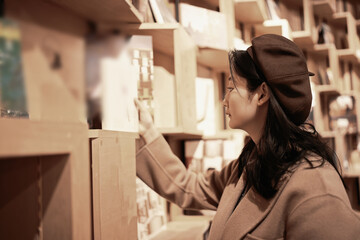 Young Woman Selecting Books in Cozy Library
