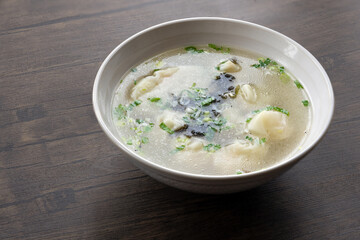 A bowl of shrimp wontons, sprinkled with seaweed and dried shrimps, traditional Chinese breakfast