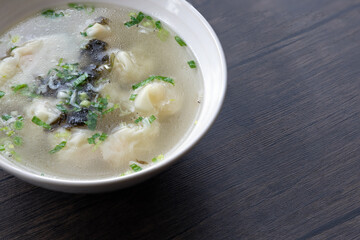 A bowl of shrimp wontons, sprinkled with seaweed and dried shrimps, traditional Chinese breakfast