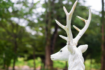 White deer statue in the forest
