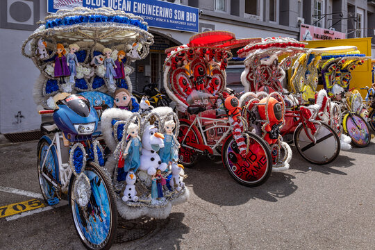 Trishaws,  or cycle rikshaws, decorated with popular film and cartoon characters and waiting to transport  tourists in Malacca, Malaysia