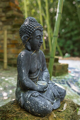 A sculpture of Buddha outdoors in nature as a religious decoration