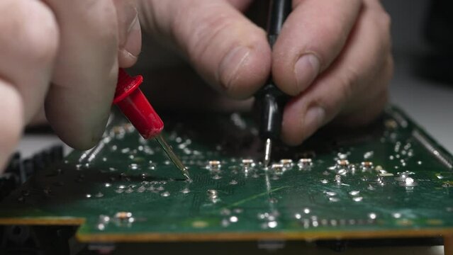 Blurred Shooting with a Technician Repairing an Electronic Circuit Board Using a Measurement Equipment in Service for Electronics. 