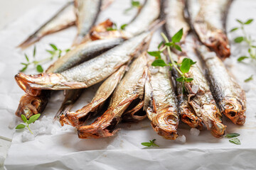 Healthy and fresh smoked sprats on white paper. - 766308107