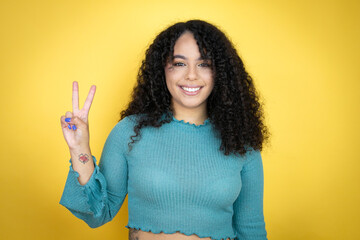 African american woman wearing casual sweater over yellow background showing and pointing up with...