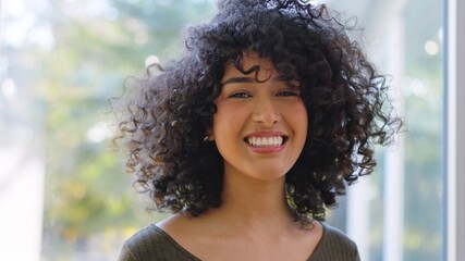 Beauty african woman with curly hair smiling at camera