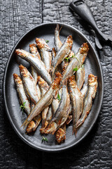 Fresh and salty smoked sprats as appetizer by the sea.