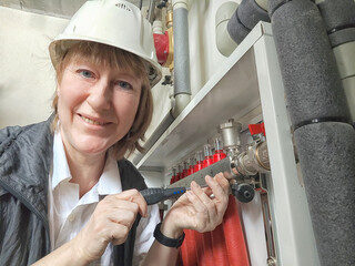 Female middle aged Technician Adjusting Industrial Water Filtration System. A woman services a...