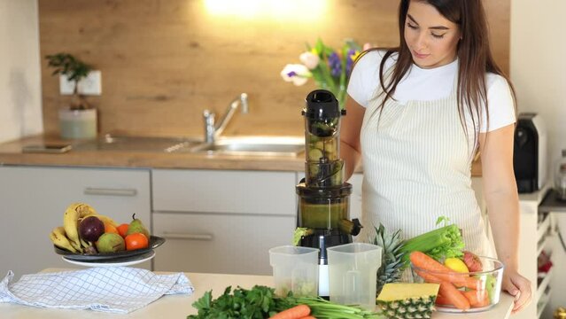 Young woman turn on juicer. Process of making healthy drink. Place for text 