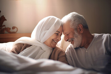 An elderly man and woman, both Oriental, lay together in bed, expressing love and closeness