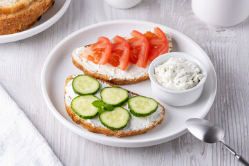 Healthy sandwiches with white cottage cheese, cucumber and tomato