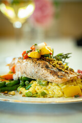 Pistachio dusted salmon filet over green beans, carrots and risotto, topped with diced pears and peaches