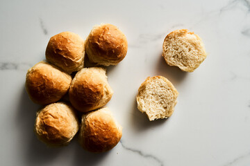 Burger Buns or mini buns on white marble background. Very soft Freshly Baked Homemade, buttered. Minimalistic photo. Top view.