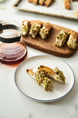 Golden Biscotti or Cantuccini on white plate on the white marble background.Traditional Sweet Italian cookies, two times baking, with nuts and dried cranberries served with filter coffee