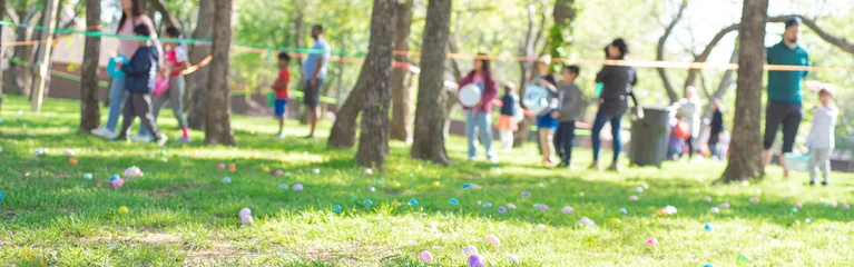 Washable wall murals Meadow, Swamp Panorama selective focus long line of diverse kids with parents after brightly colored barricade tape and multicolor Easter eggs on Church grass meadow field ready for egg hunt tradition, Texas