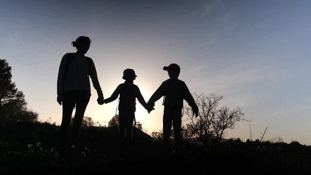 Silhouette of family spending time outdoors together at sunset