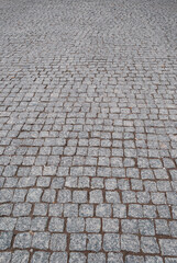 Closeup of road paved with gray cobblestones