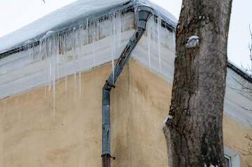 icicles on the roof of an old house - 766361110