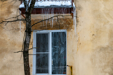 icicles on the roof of an old house - 766361123