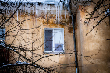 icicles on the roof of an old house - 766361126