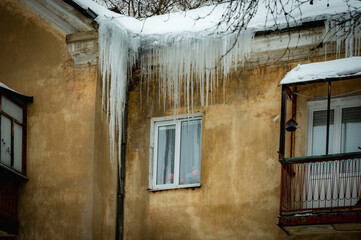 icicles on the roof of an old house - 766361143