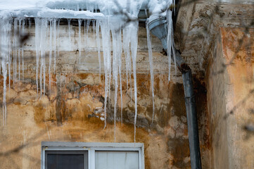 icicles on the roof of an old house - 766361149