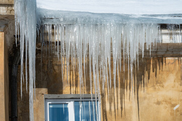 icicles on the roof of an old house - 766361154