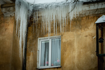 icicles on the roof of an old house - 766361155