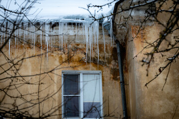 icicles on the roof of an old house - 766361158