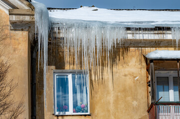 icicles on the roof of an old house - 766361160