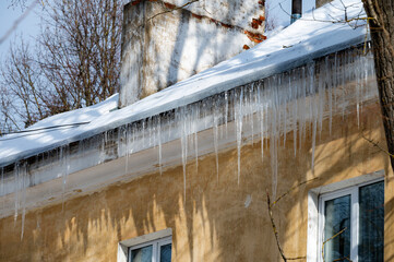 icicles on the roof of an old house - 766361162