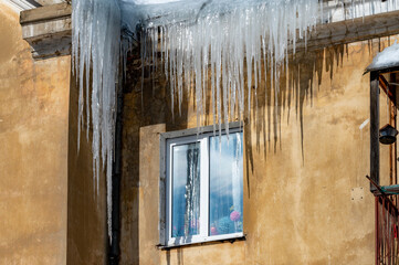 icicles on the roof of an old house - 766361167