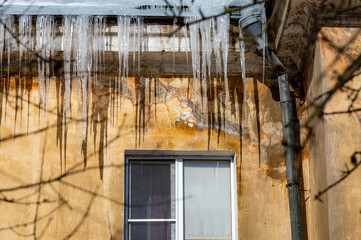 icicles on the roof of an old house - 766361180