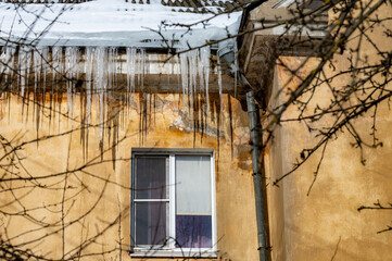 icicles on the roof of an old house - 766361181