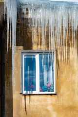 icicles on the roof of an old house - 766361187