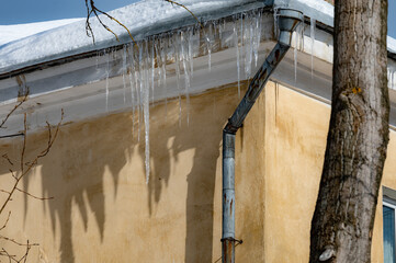 icicles on the roof of an old house - 766361189
