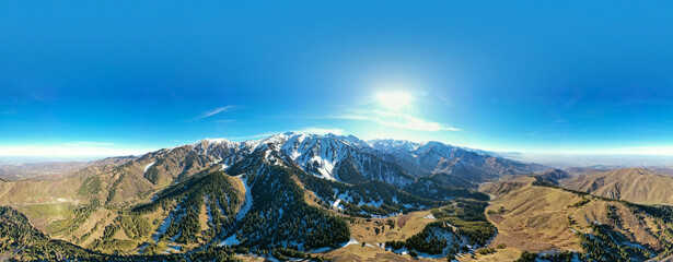 Panoramic view of mountainside lit by setting sun in the rocky mountains. The glow of the sun...