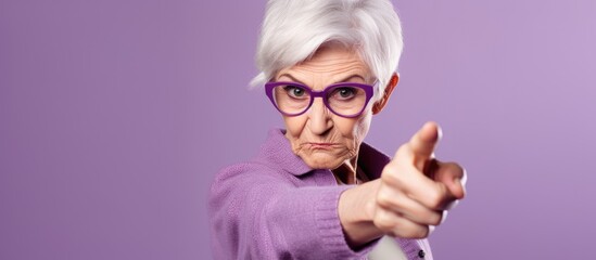 An elderly woman with violet glasses gestures towards the camera with her thumb and finger, showcasing the importance of vision care