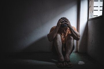 Asian man addict drug in the deserted place,A junkie feels alone in this world,Sad young man sitting in the corner of the room,People are stressed and have depression - obrazy, fototapety, plakaty