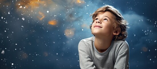 A young kid with curious eyes staring up at the vast blue sky above in wonder and amazement - obrazy, fototapety, plakaty